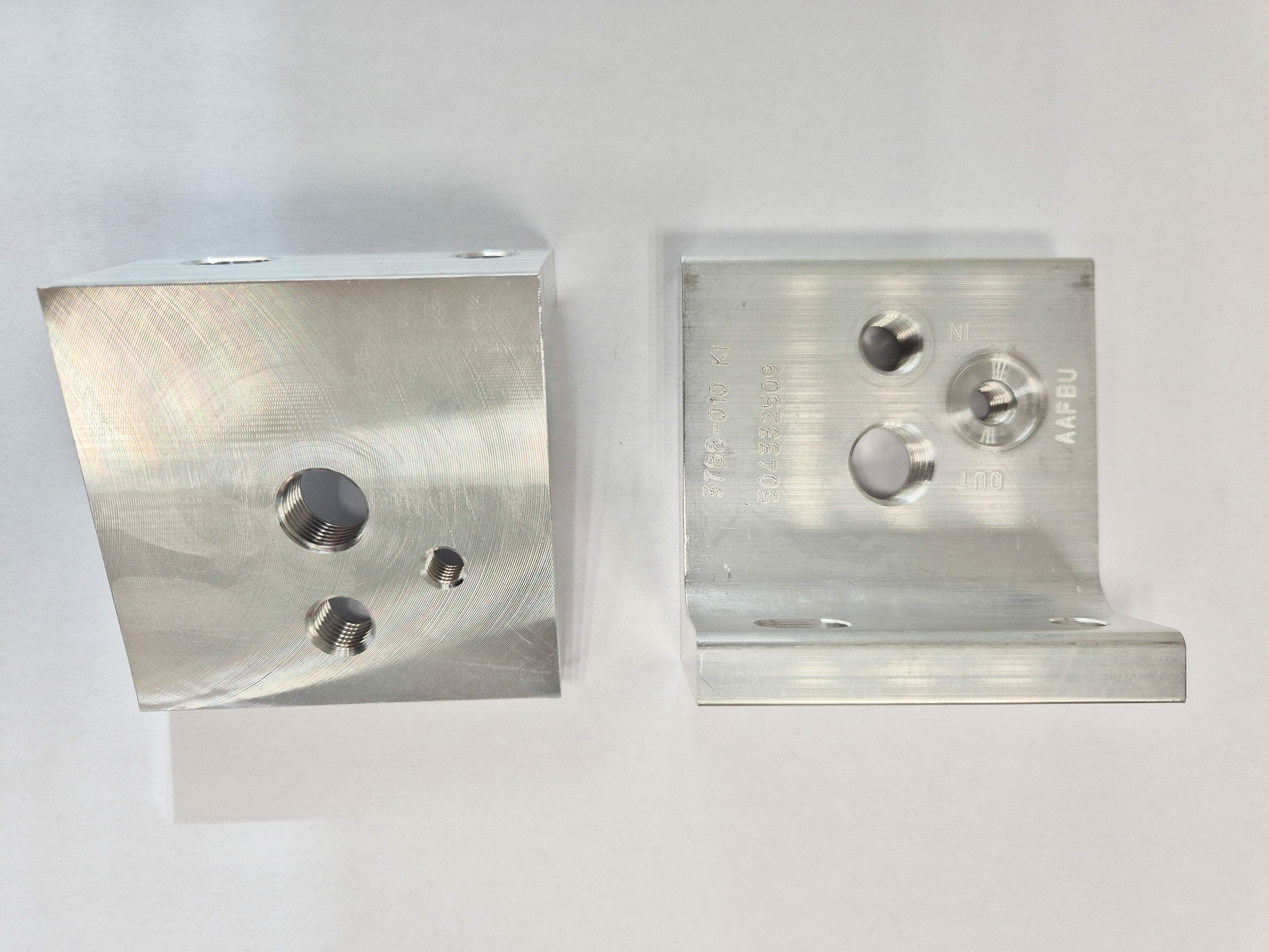 Pièces moyenne métallique usinées en aluminium, comportant plusieurs perçages filetés et marquages techniques