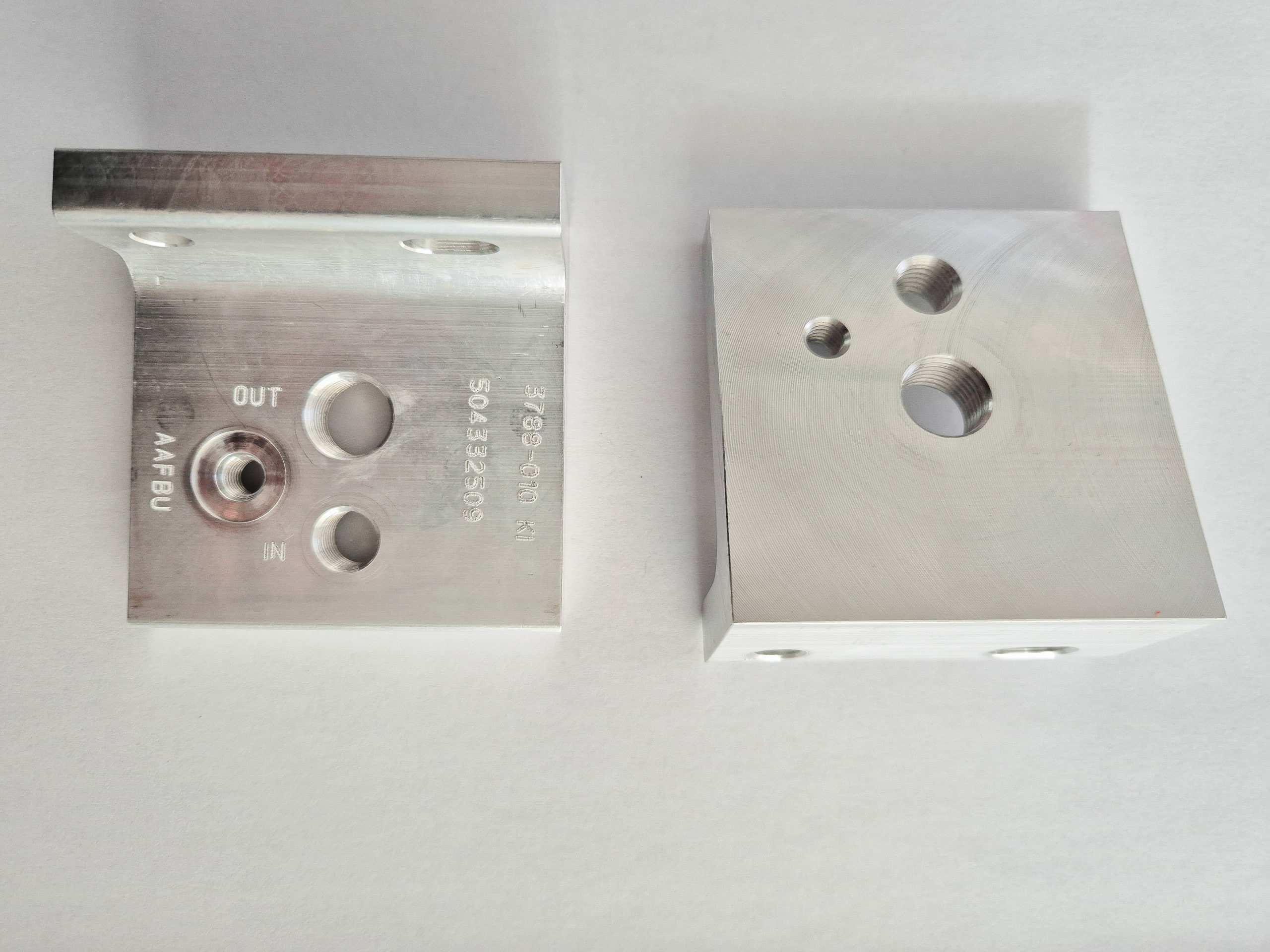 Pièces moyenne métallique usinées en aluminium, comportant plusieurs perçages filetés et marquages techniques